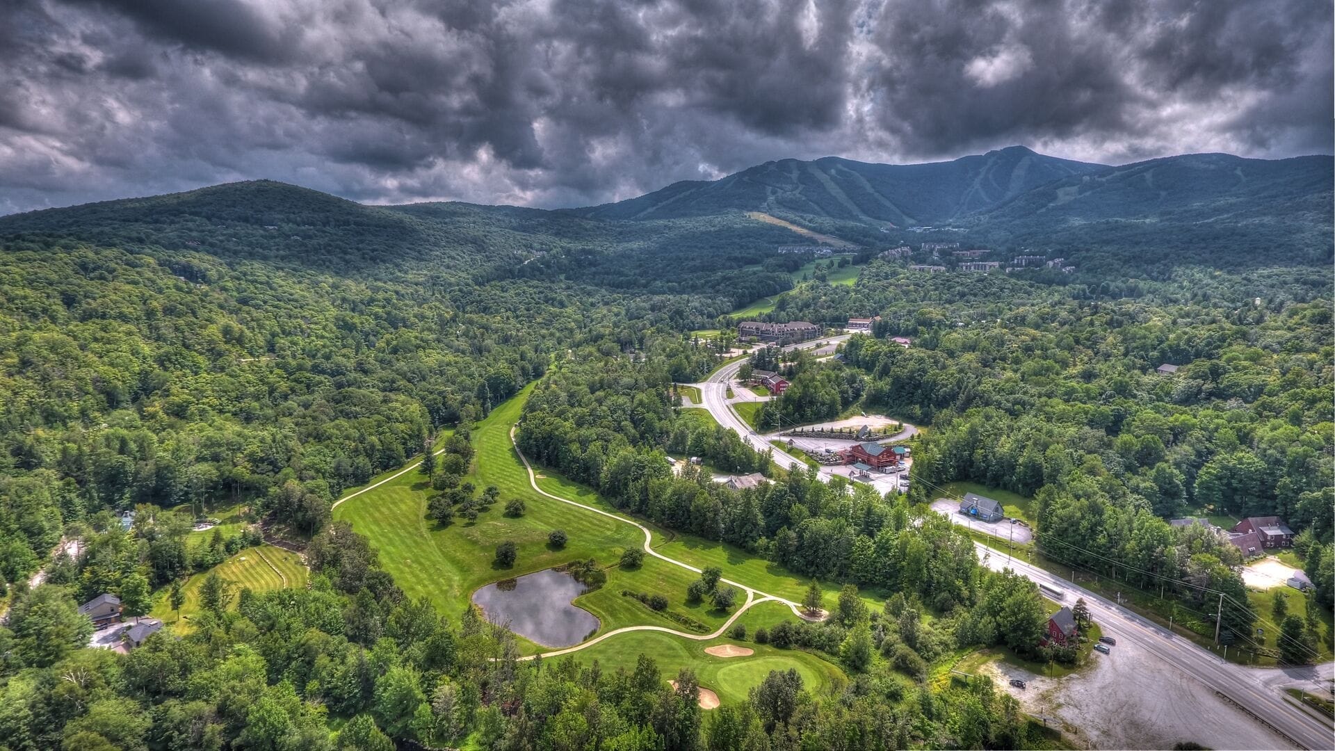 Aerial view of Mountain Green Resort vacation rental condos with golf course and mountain backdrop in Killington Vermont