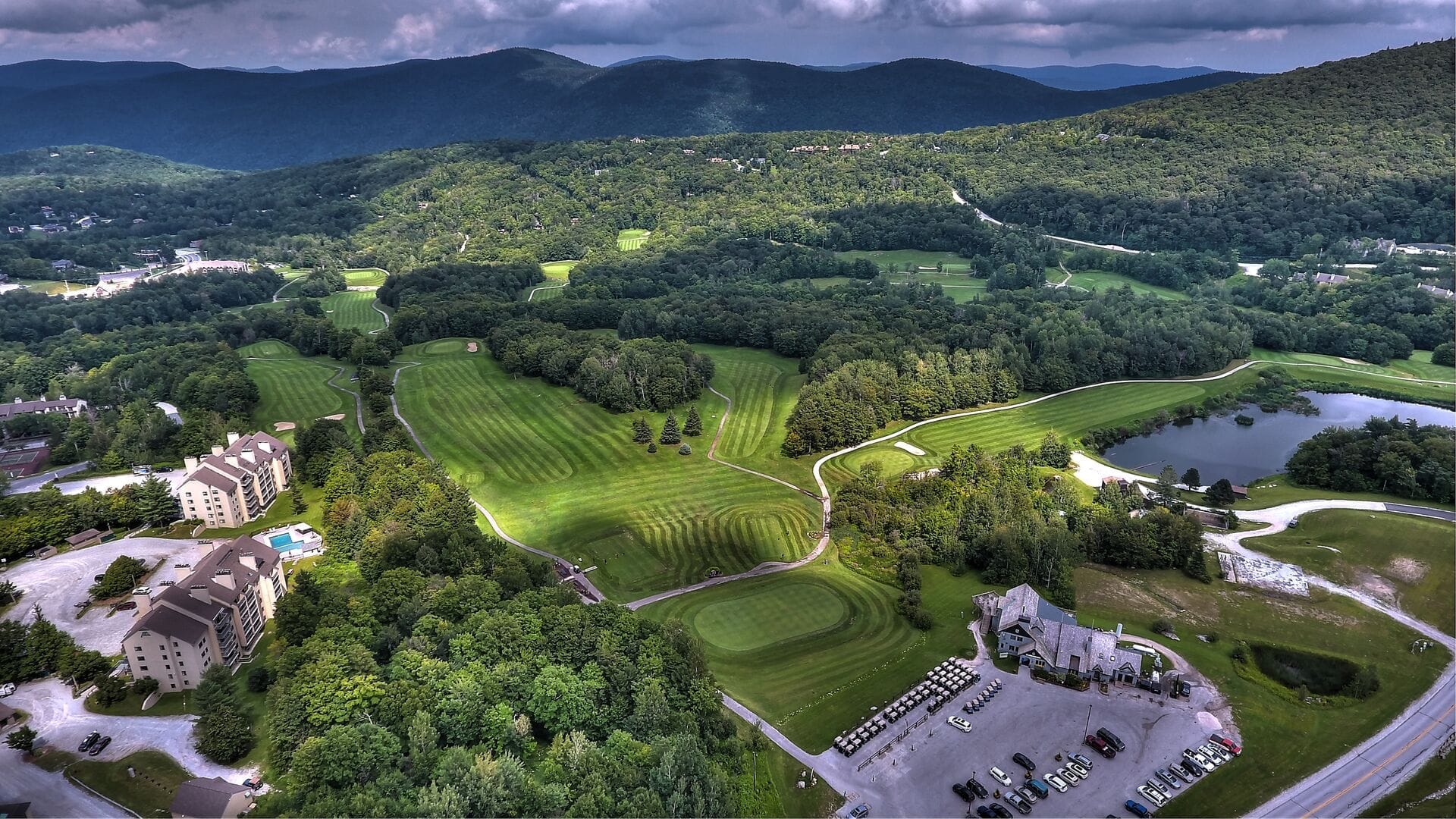 Aerial photograph of golf course fairways and greens beside Mountain Green Resort in Killington