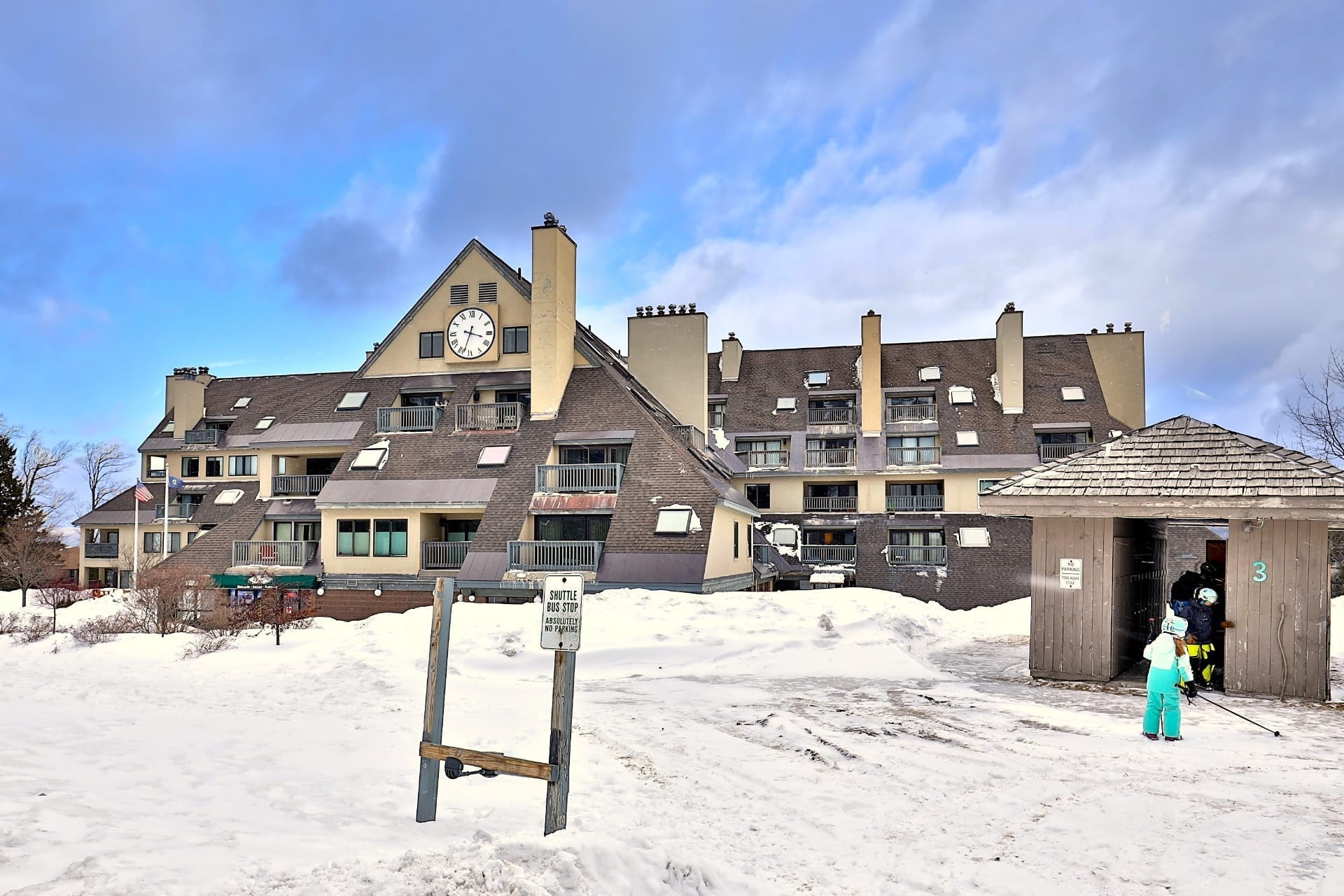 Snow-covered Mountain Green Resort condo buildings at the base of Killington ski area during peak winter season with ski slopes in background